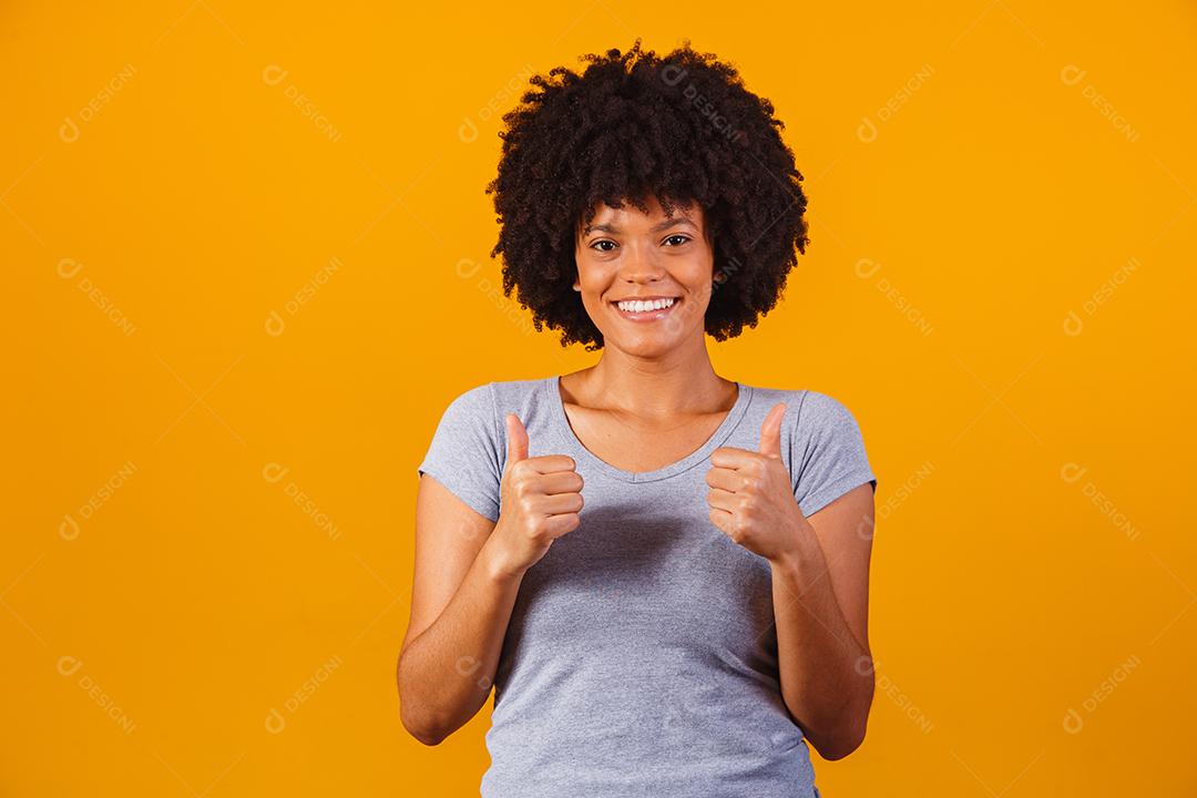 Retrato de sorrir bela jovem afro polegares para cima. menina brasileira.