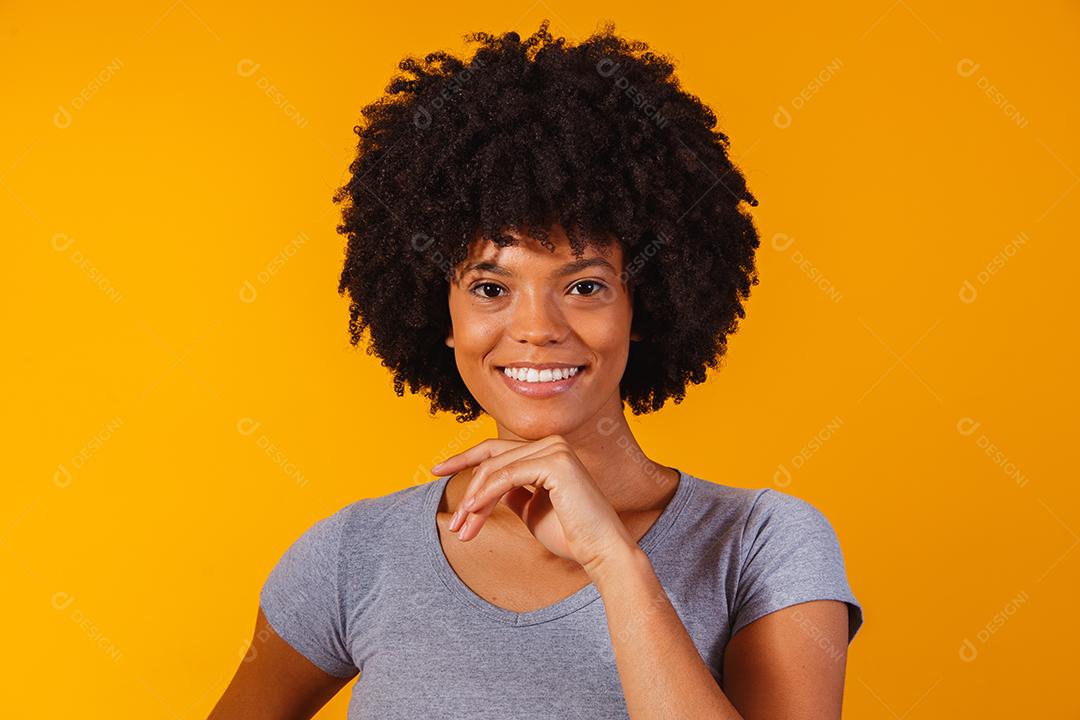mulher afro com cabelo preto sorrindo olhando para a câmera