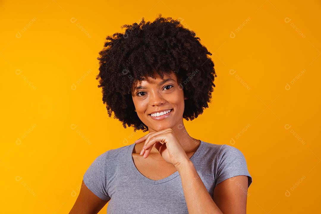 mulher afro com cabelo preto sorrindo olhando para a câmera