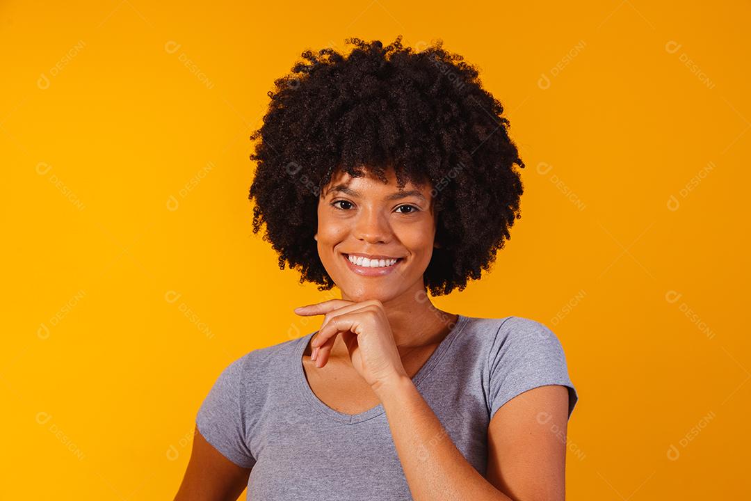 mulher afro com cabelo preto sorrindo olhando para a câmera