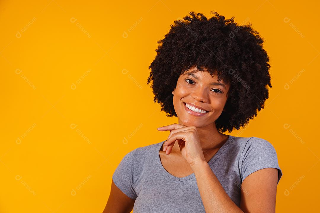 mulher afro com cabelo preto sorrindo olhando para a câmera