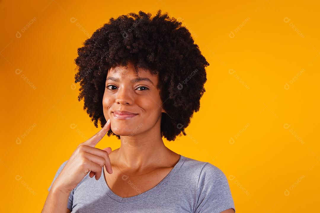 Mulher afro pensando em fundo amarelo