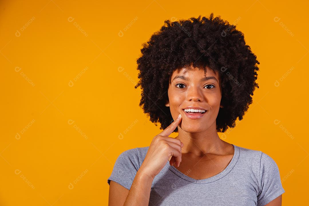 Mulher afro pensando em fundo amarelo