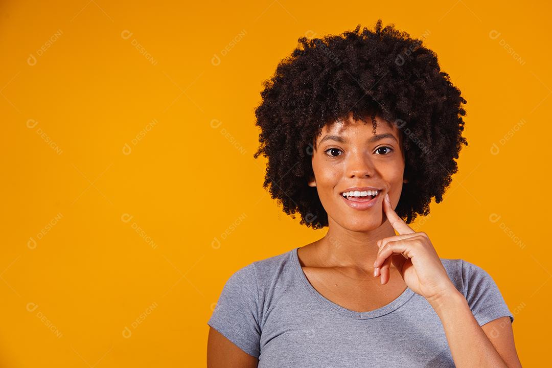 Mulher afro pensando em fundo amarelo