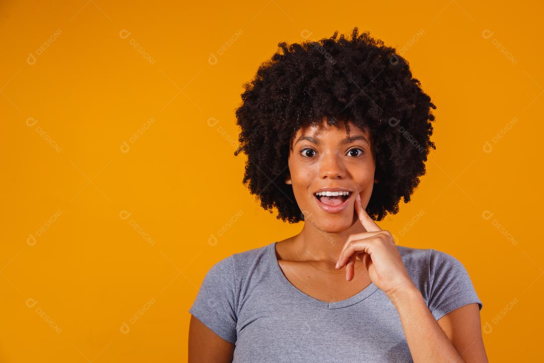 Mulher cabelo afro expressão fundo amarelo
