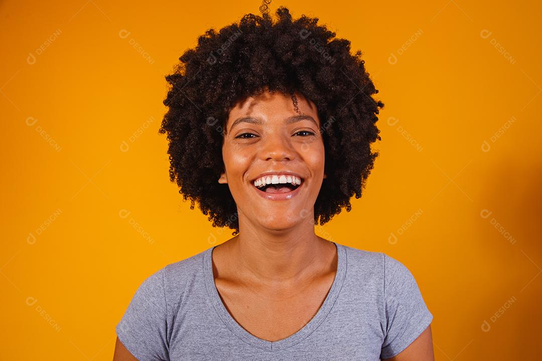 Linda garota afro-americana com um penteado afro sorrindo. Mulher com cabelo black power para propaganda de xampu