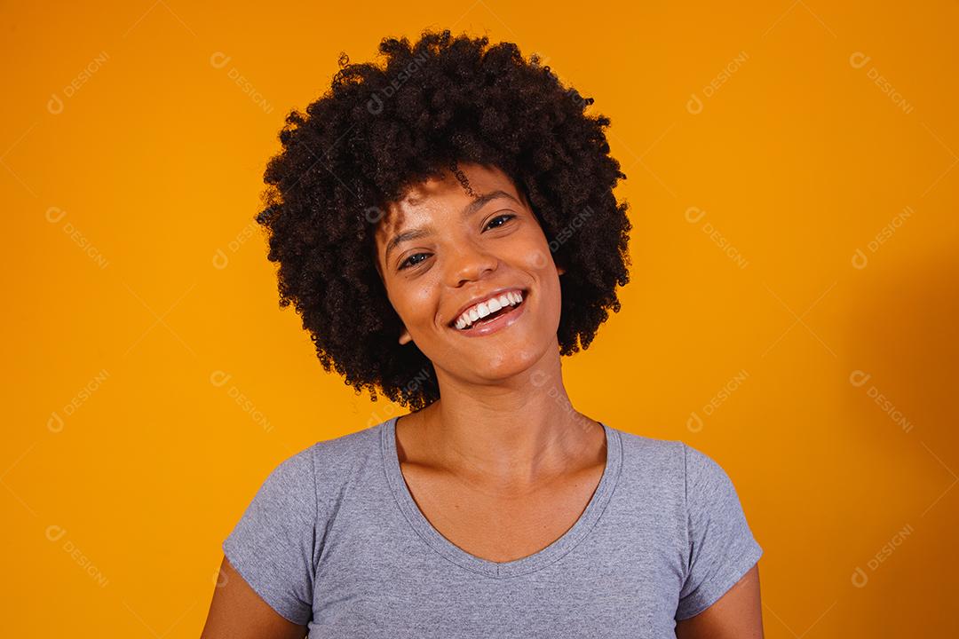 Linda garota afro-americana com um penteado afro sorrindo. Mulher com cabelo black power para propaganda de xampu