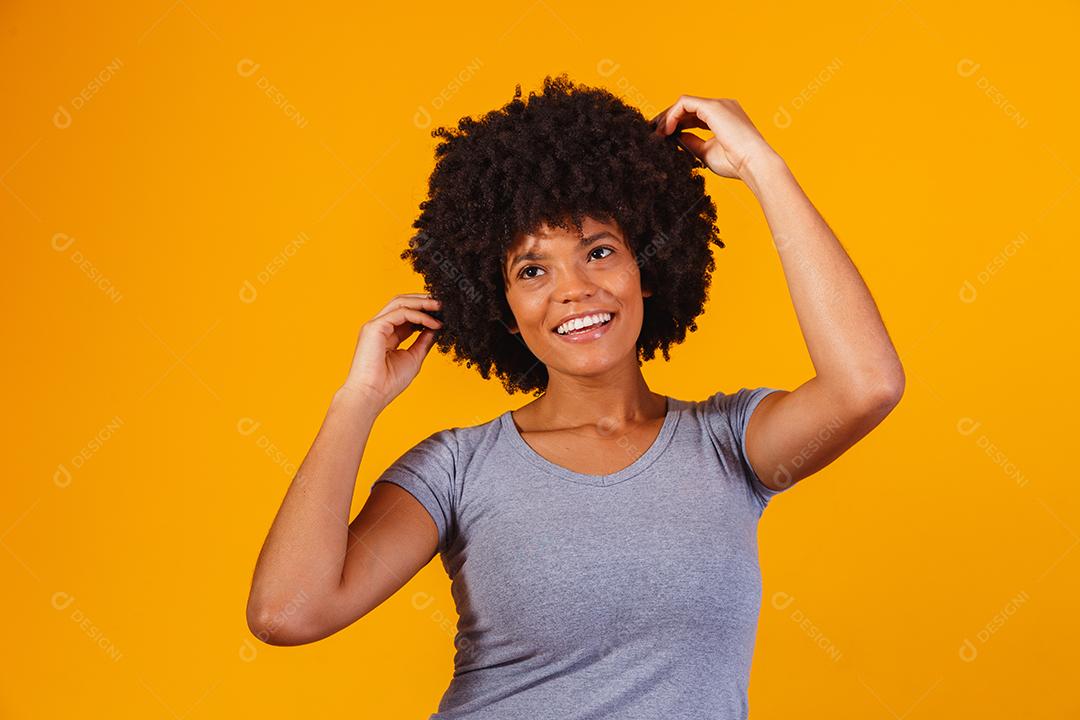 Linda garota afro-americana com um penteado afro sorrindo. Mulher com cabelo black power para propaganda de xampu