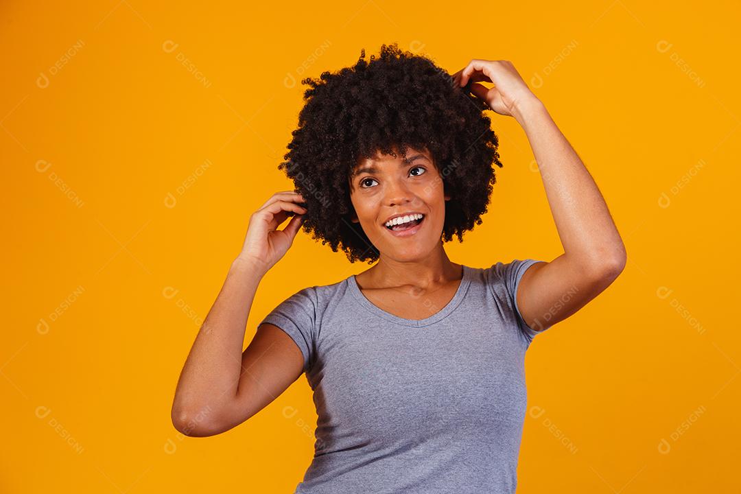 Linda garota afro-americana com um penteado afro sorrindo. Mulher com cabelo black power para propaganda de xampu