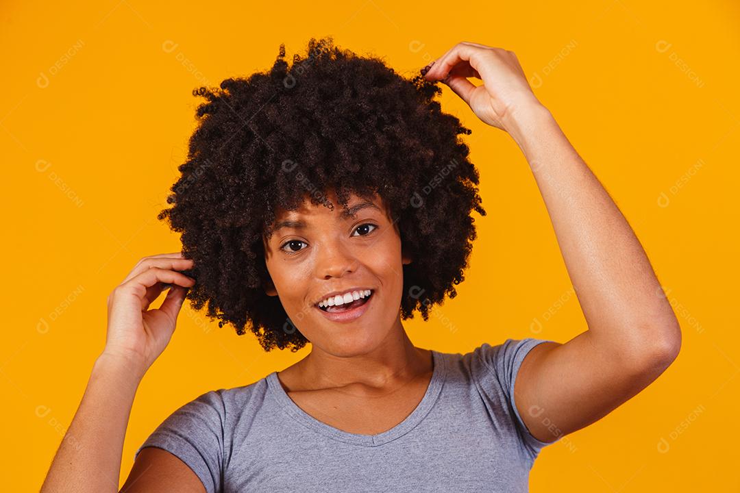 Linda garota afro-americana com um penteado afro sorrindo. Mulher com cabelo black power para propaganda de xampu