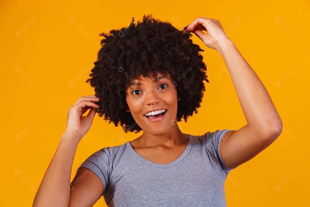 Linda garota afro-americana com um penteado afro sorrindo. Mulher com cabelo black power para propaganda de xampu