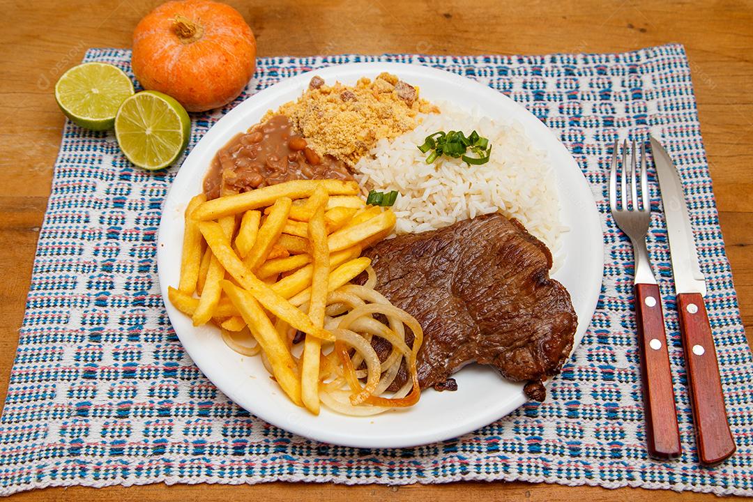 Plate of rice, beans, french fries and steak