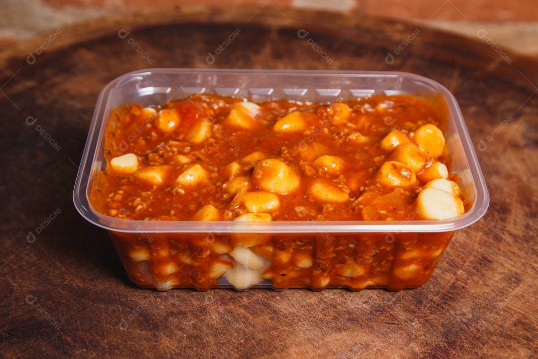 Massa italiana brasileira Nhoque em tigela descartável sobre mesa de madeira