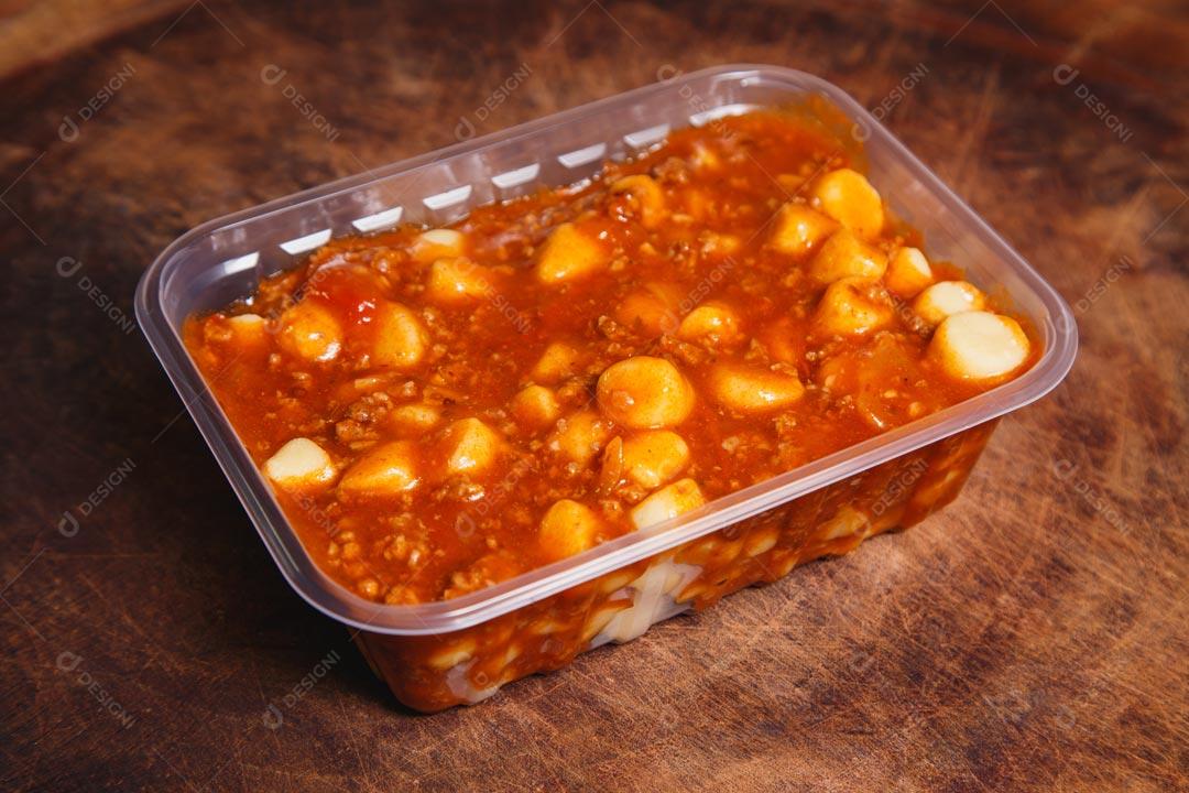 Massa italiana brasileira Nhoque em tigela descartável sobre mesa de madeira