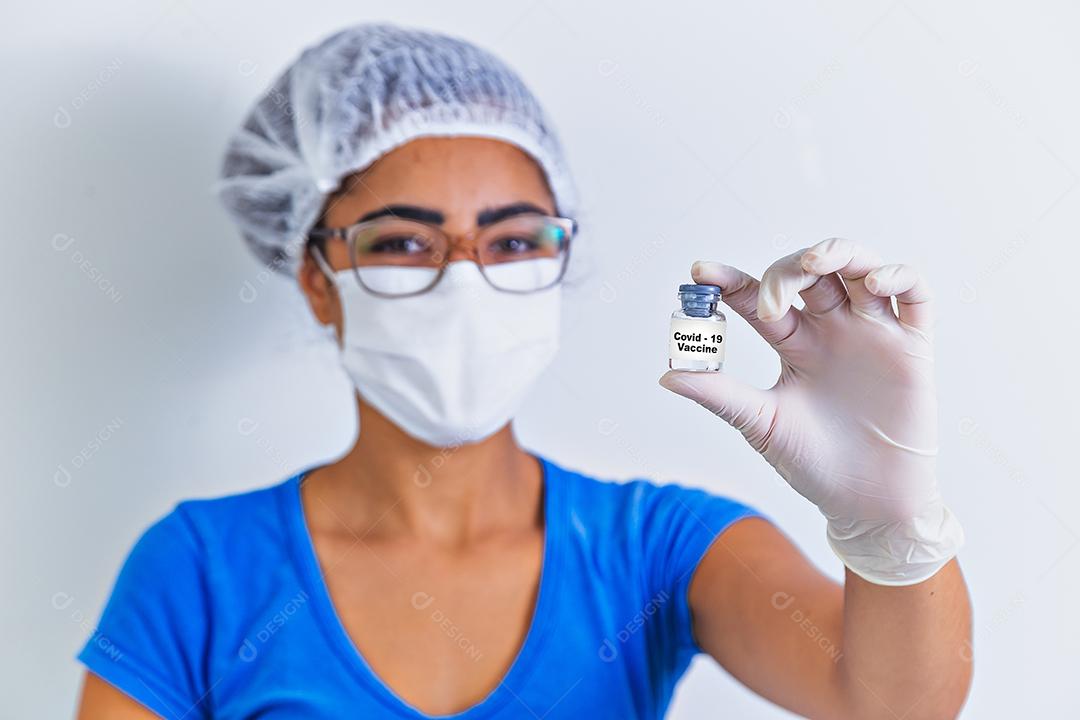 Vacina COVID-19 nas mãos do pesquisador, médica segura seringa e garrafa com vacina para cura de coronavírus