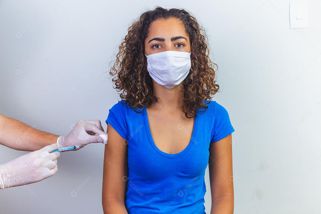 mulher afro recebendo vacina para imunizar o vírus