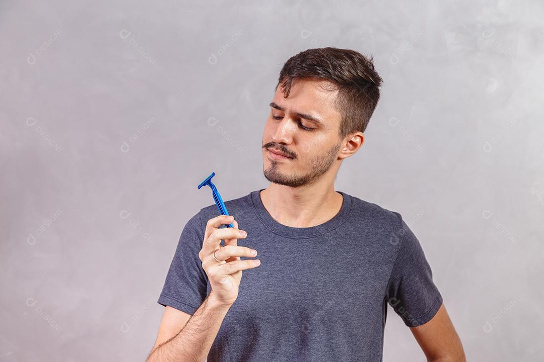 Homem Jovem segurando a lâmina de barbear