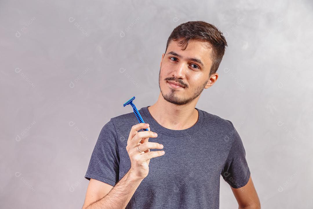 Homem Jovem segurando a lâmina de barbear