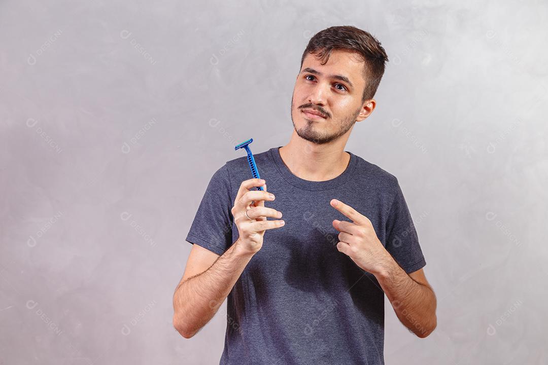 Homem Jovem segurando a lâmina de barbear