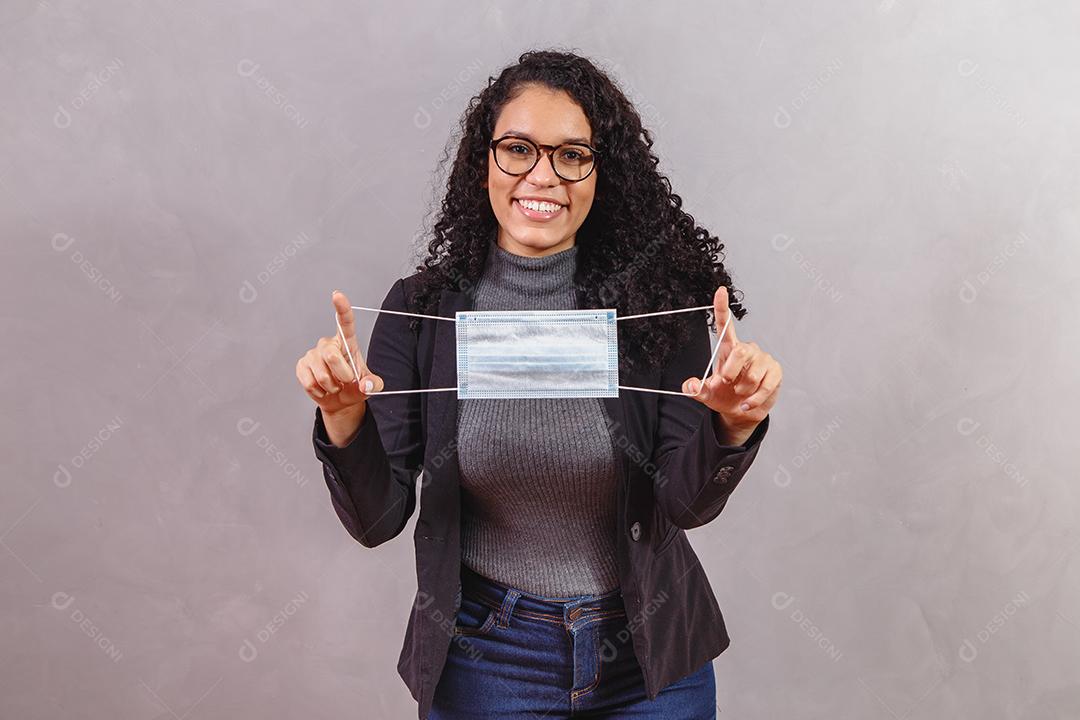 Mulher de negócios afro segurando máscara