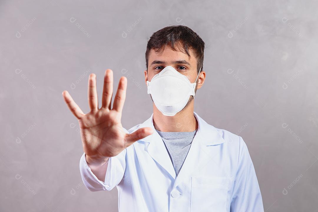 Jovem Médico da UTI do Reino Unido gesticulando com a mão Parar Coronavirus