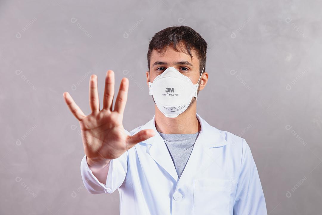 Jovem Médico da UTI do Reino Unido gesticulando com a mão Parar Coronavirus