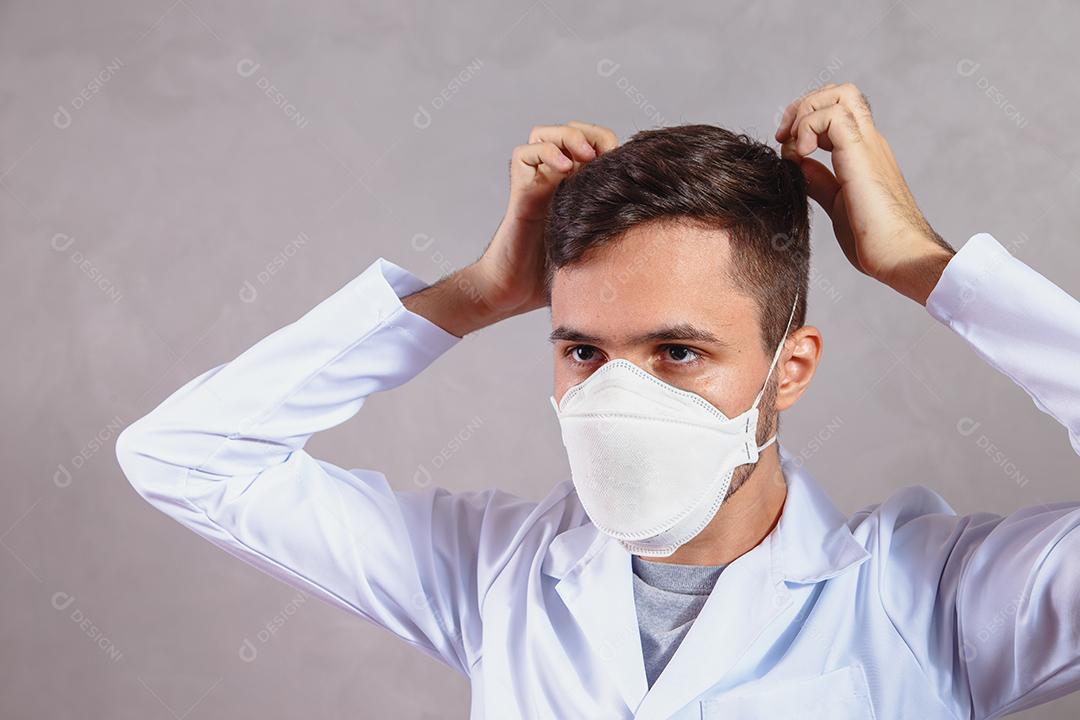 Jovem Médico colocando máscara protetora