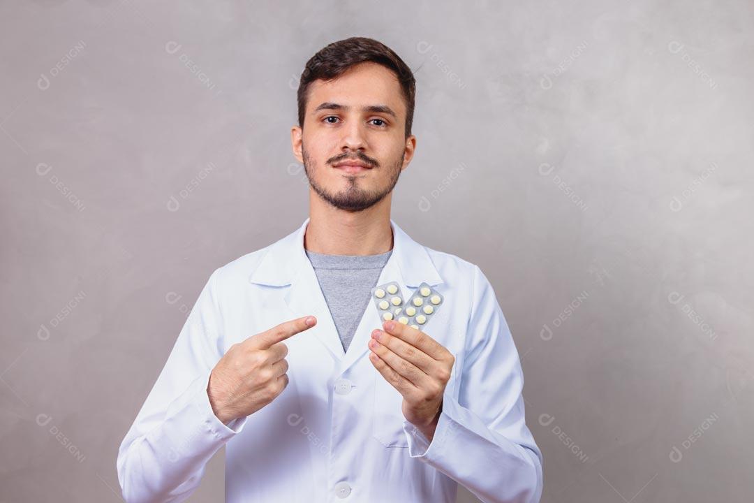 Homem Médico Com Jaleco Branco Segurando Copo de Água e Comprimidos