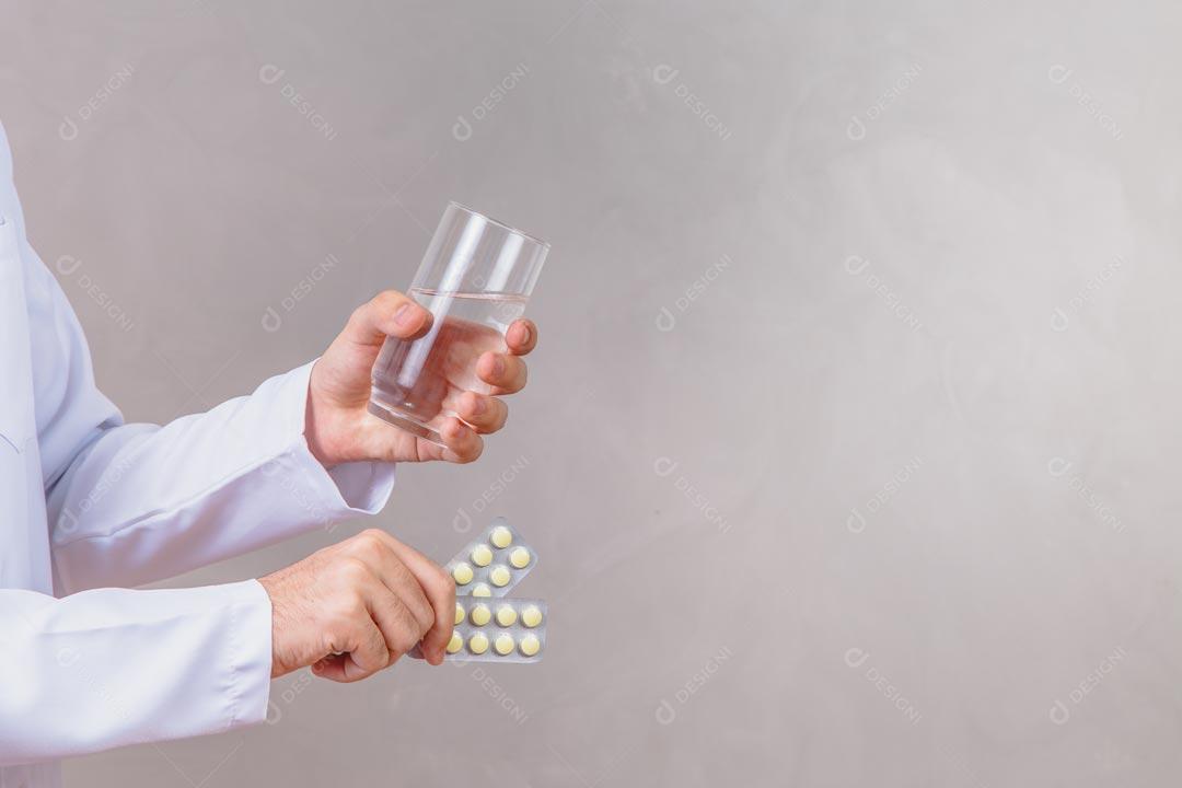 Hand Holding Medicine Pills And Glass Of Water