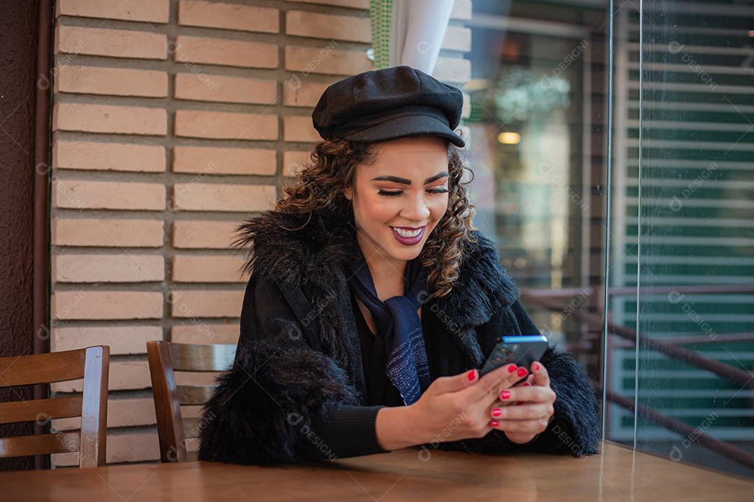 Mulher Afro usando celular para trabalhar