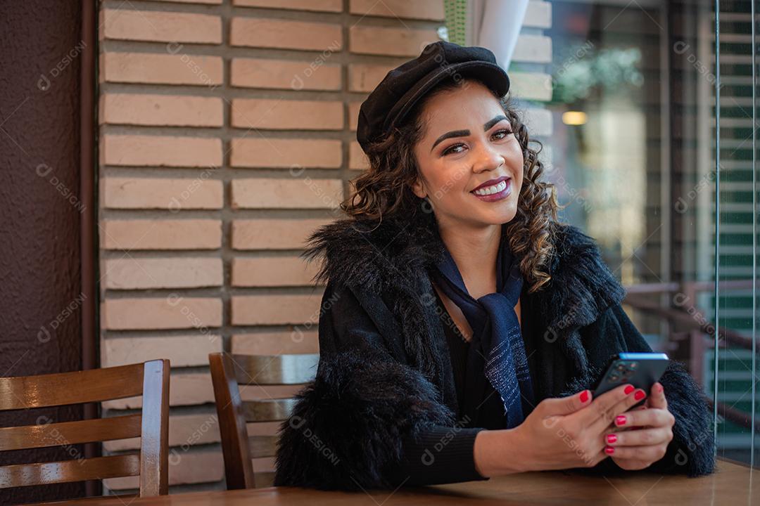 Mulher Afro usando celular para trabalhar