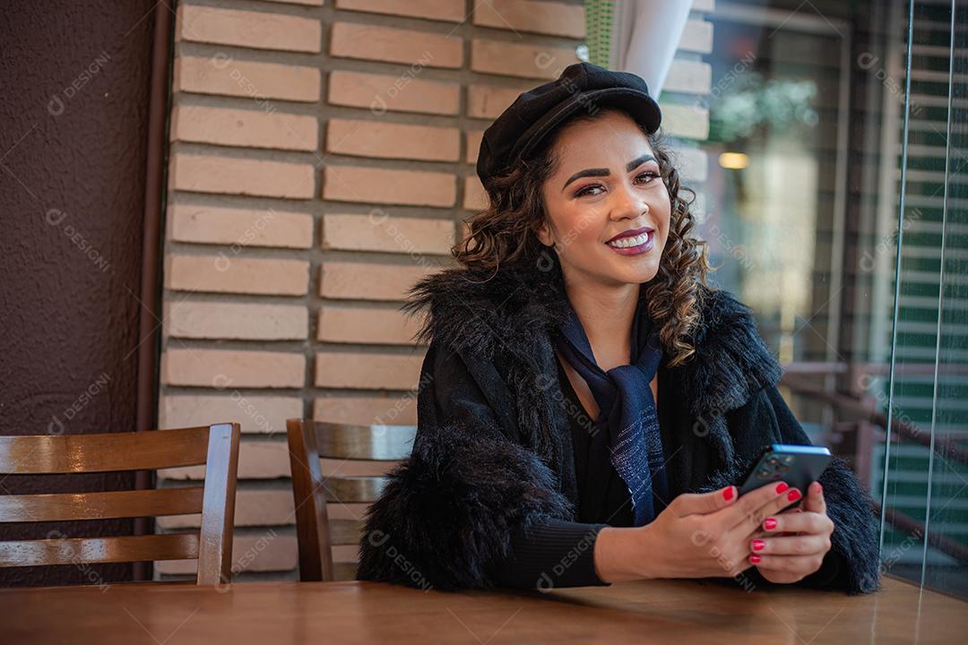 Mulher Afro usando celular para trabalhar