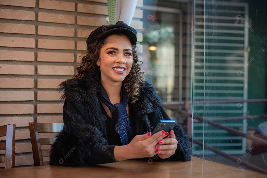 Mulher Afro usando celular para trabalhar