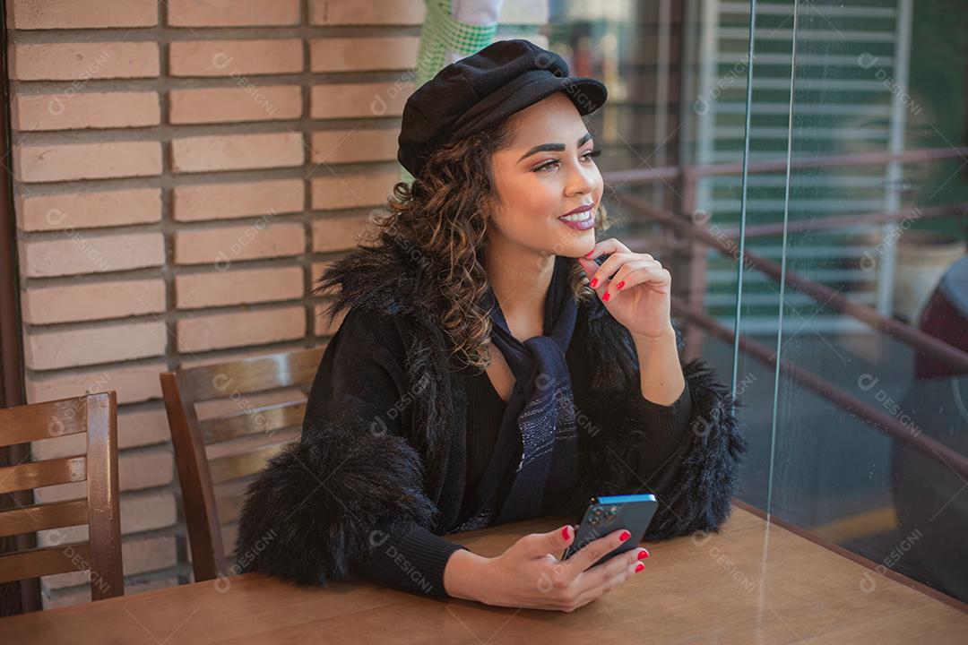 Mulher Afro usando celular para trabalhar