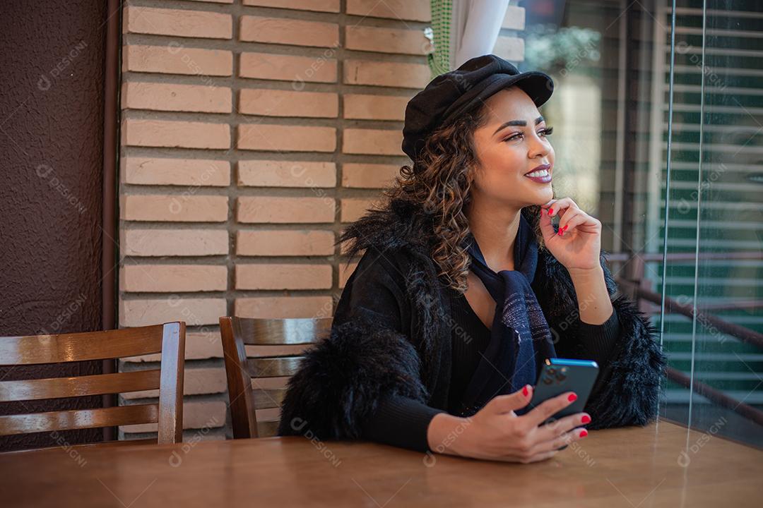 Mulher Afro usando celular para trabalhar