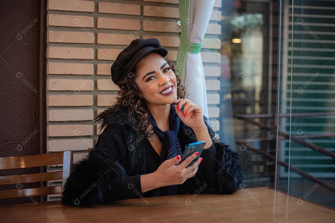 Mulher Afro usando celular para trabalhar