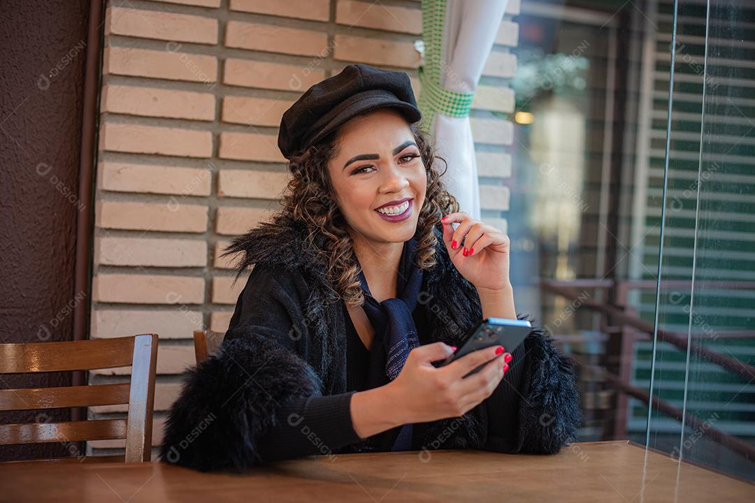 Mulher Afro usando celular para trabalhar