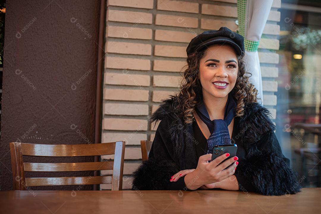 Mulher Afro usando celular para trabalhar