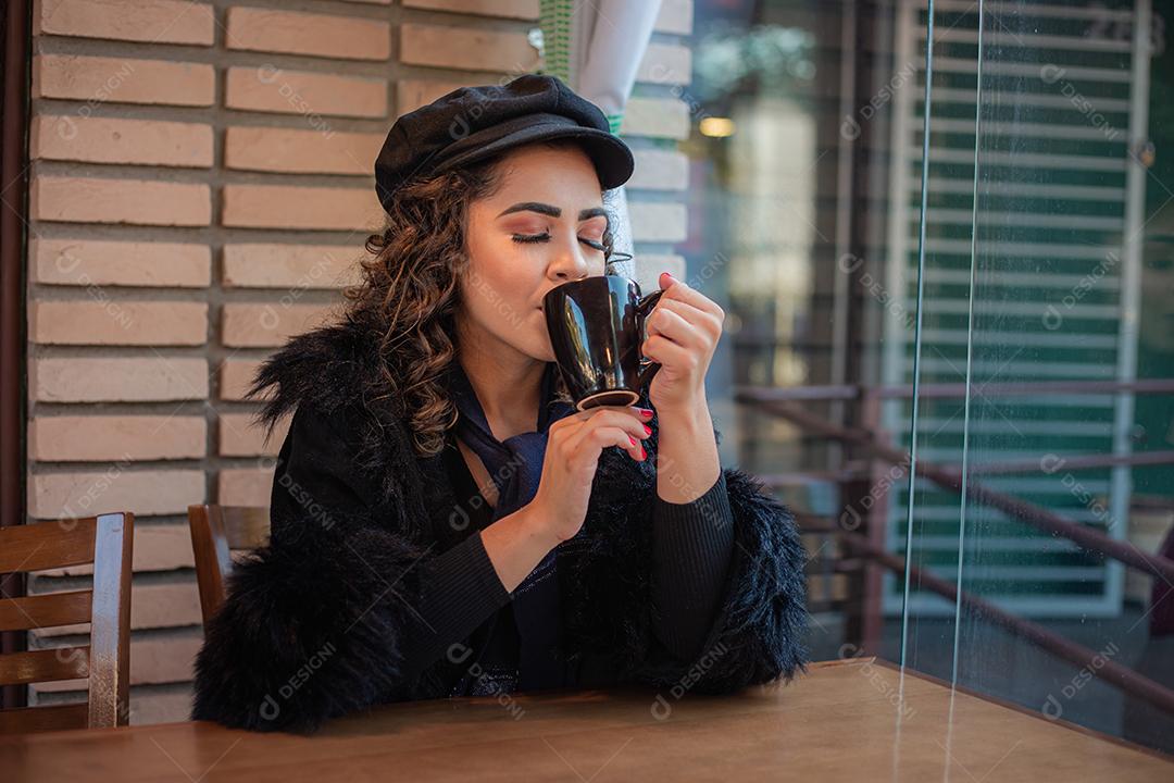 Mulher Afro bebendo café na Padaria