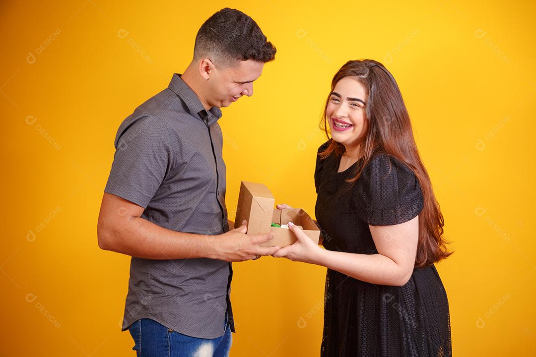 Casal de namorados com caixa de doces fazendo surpresa