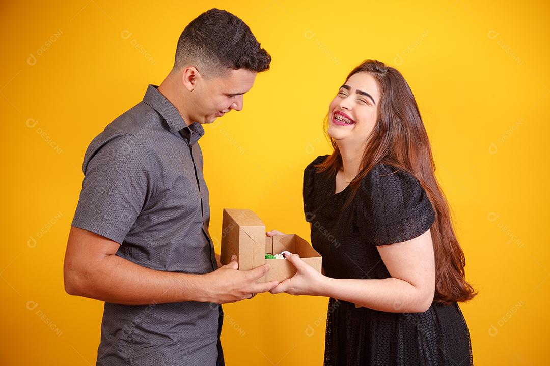 Casal de namorados com caixa de doces fazendo surpresa