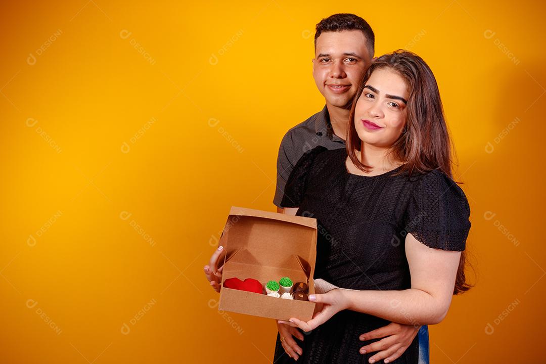 Casal de namorados com caixa de doces fazendo surpresa