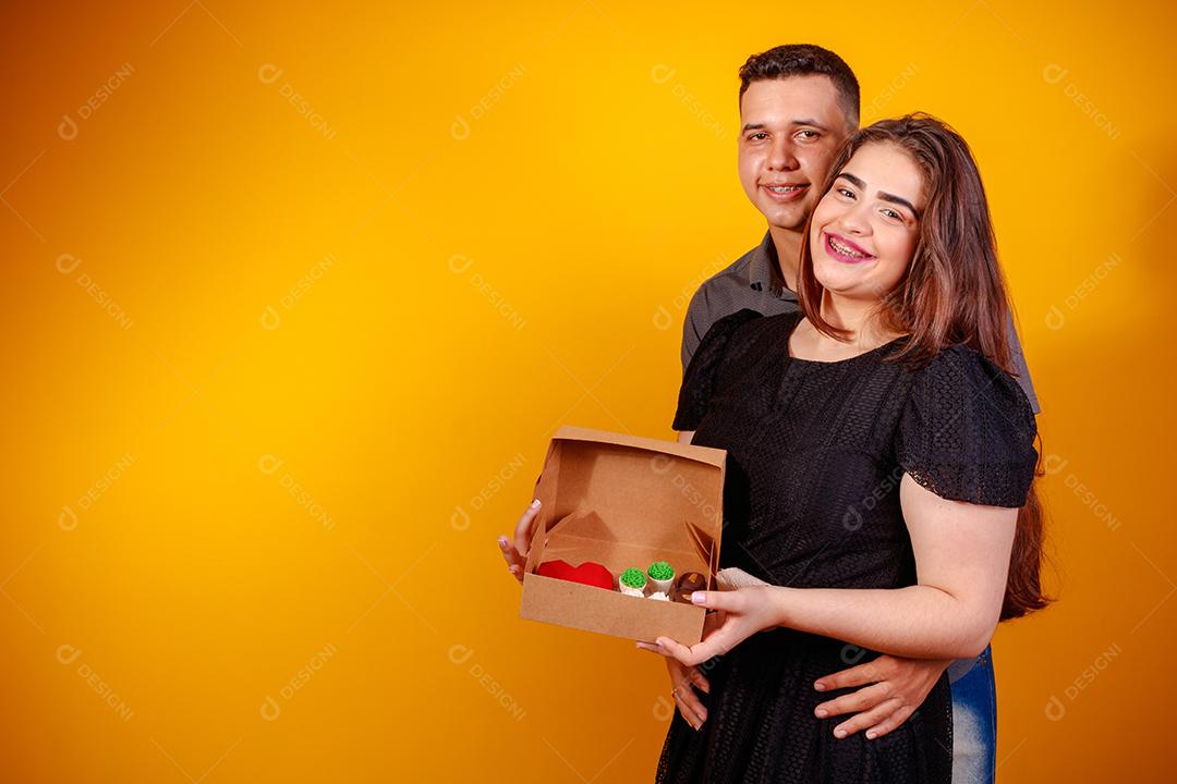 Casal de namorados com caixa de doces fazendo surpresa