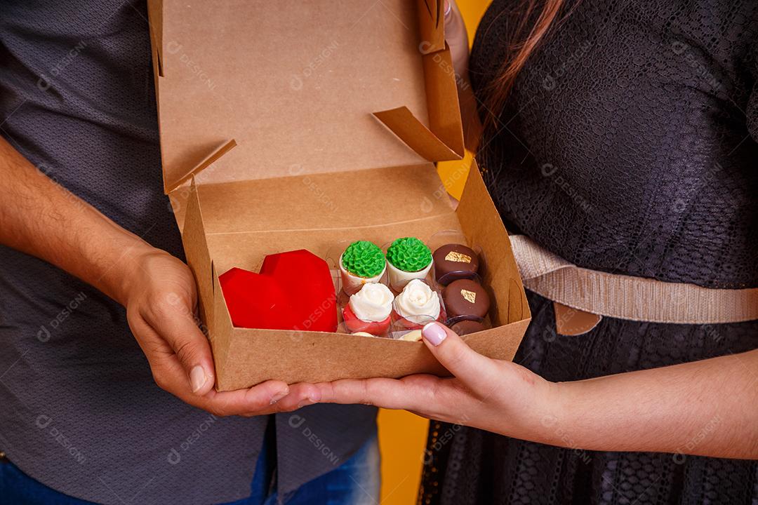 Casal de namorados com caixa de doces fazendo surpresa