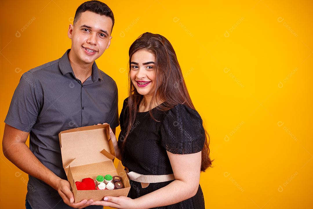 Casal de namorados com caixa de doces fazendo surpresa