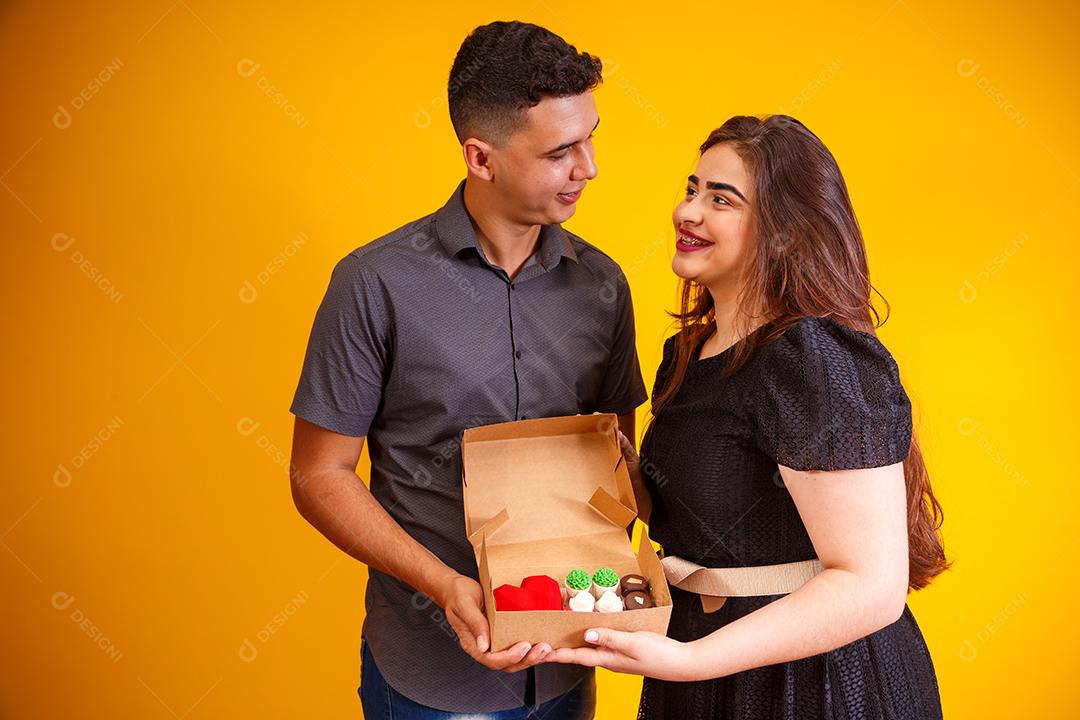 Casal de namorados com caixa de doces fazendo surpresa