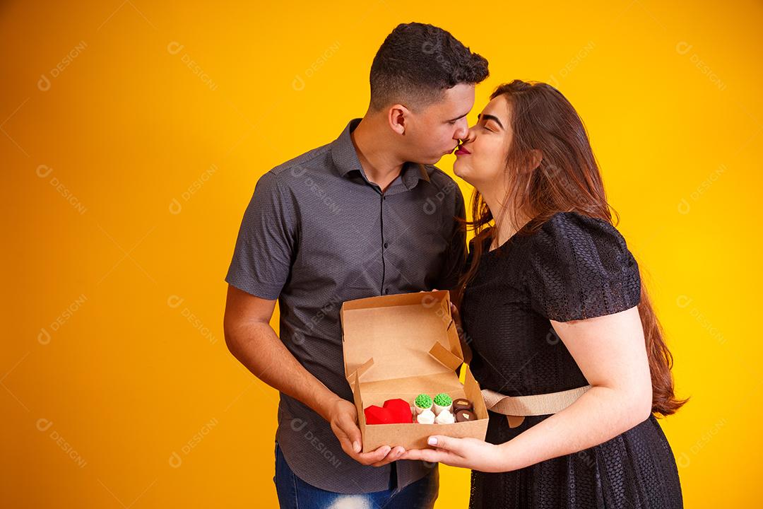 Casal de namorados com caixa de doces fazendo surpresa