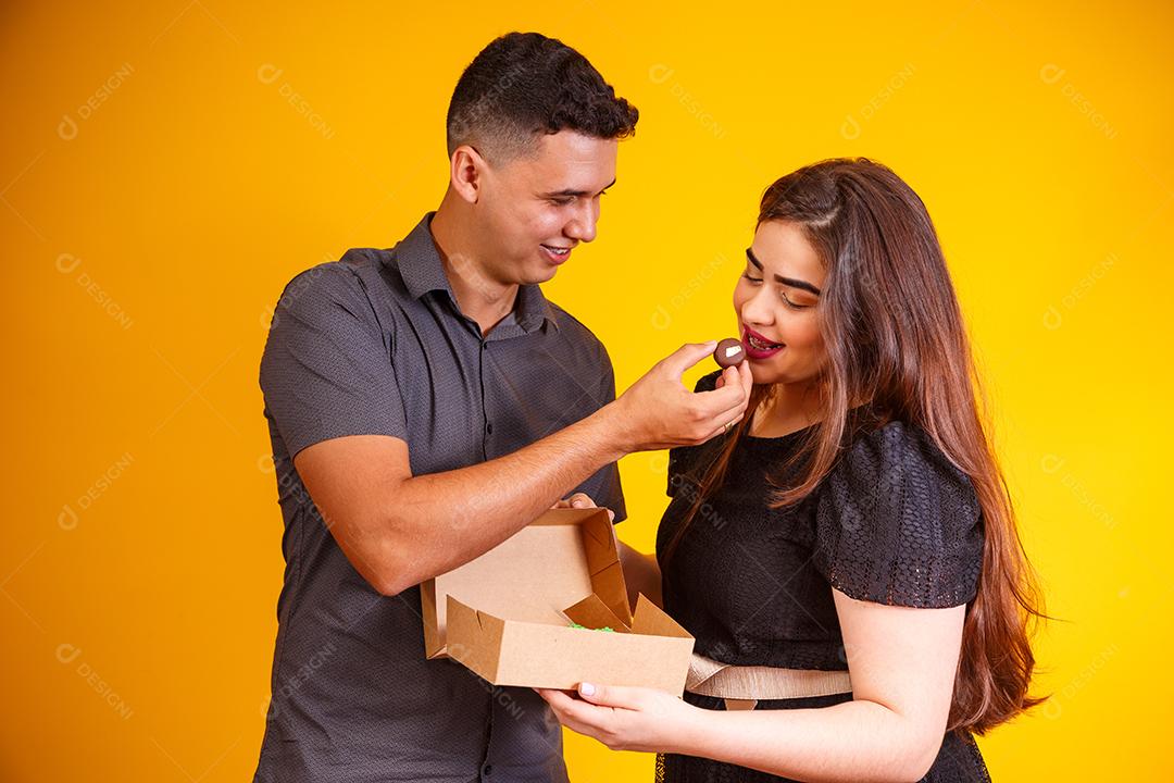 Casal de namorados com caixa de doces fazendo surpresa