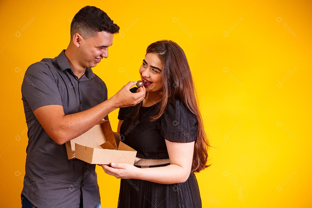 Casal de namorados com caixa de doces fazendo surpresa