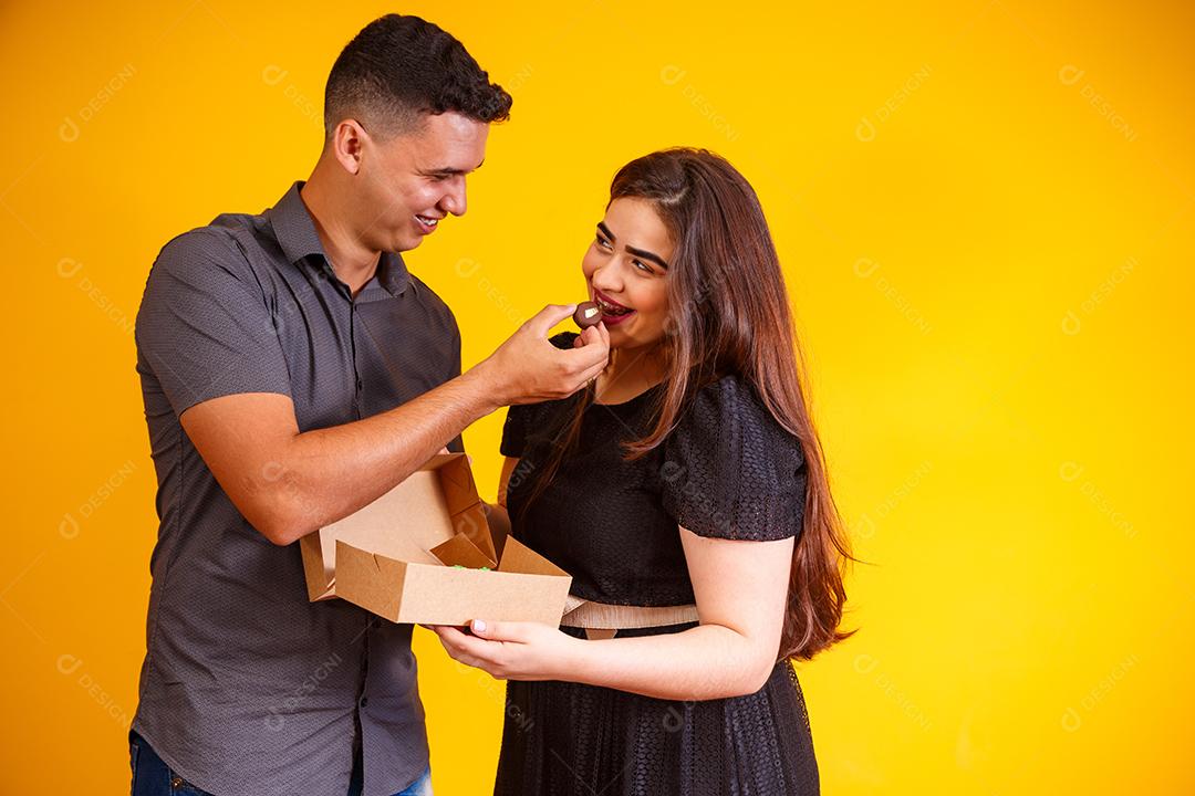 Casal de namorados com caixa de doces fazendo surpresa